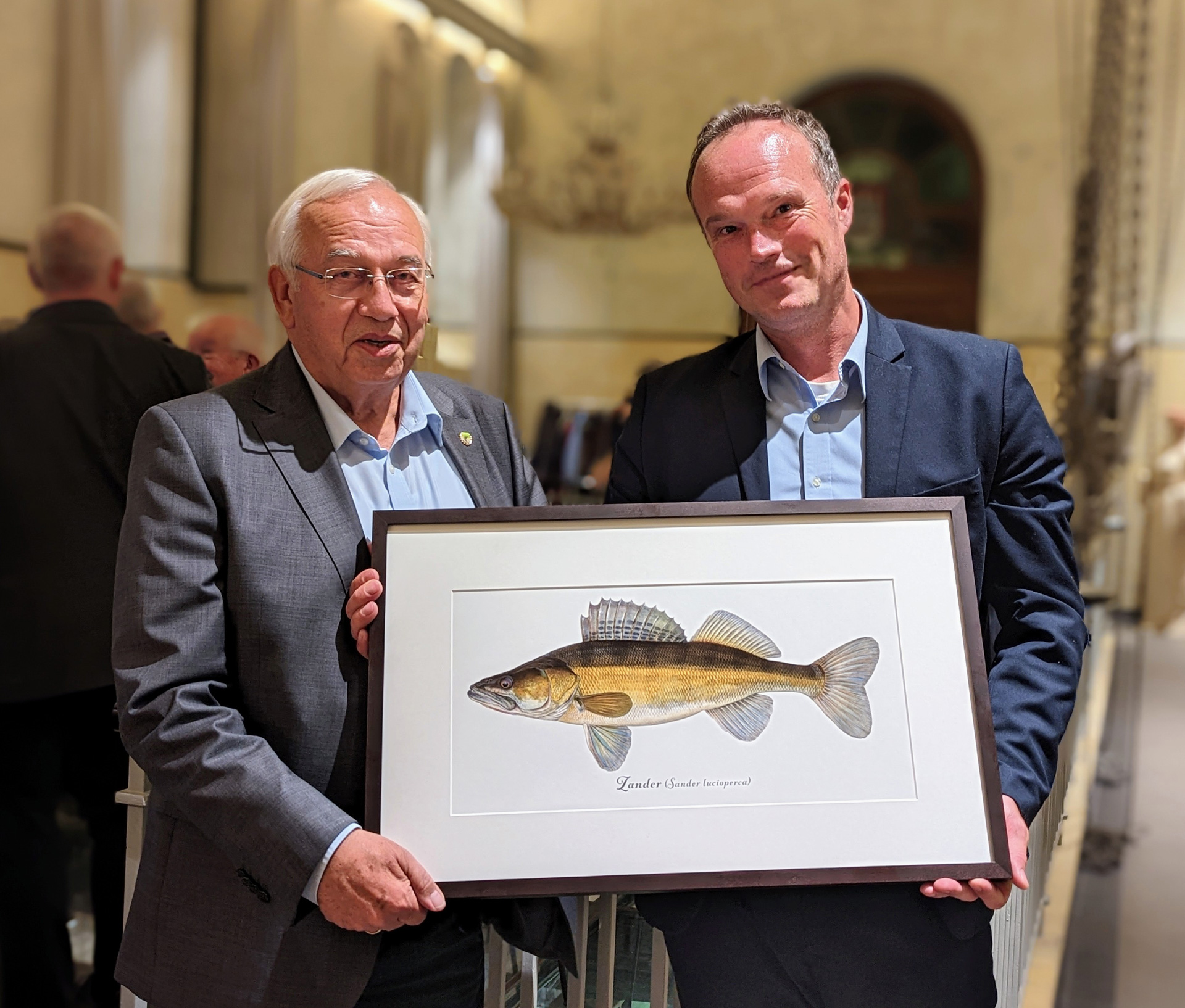 Klaus-Dieter Mau, Präsident des DAFV überreicht einen Kunstdruck vom Zander an Martin Liebetanz-Vahldiek von der Fischereibehörde in Hamburg. Bild: DAFV, Olaf Lindner